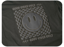 Black puff print on a black t-shirt has a smiley face in the center and reads "Good Vibes Only" above and below