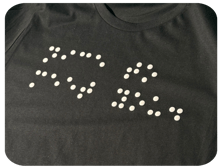 White puff print on a black tee reads "Nice to meet you" in Braille